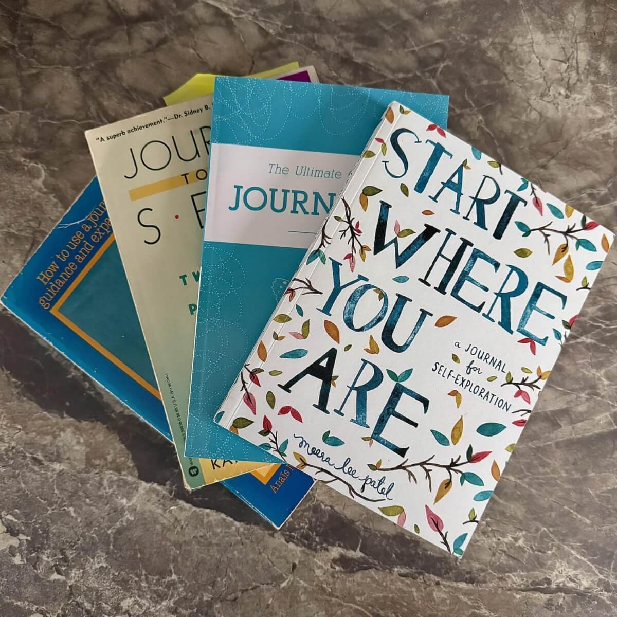 Four Journaling books stacked together
