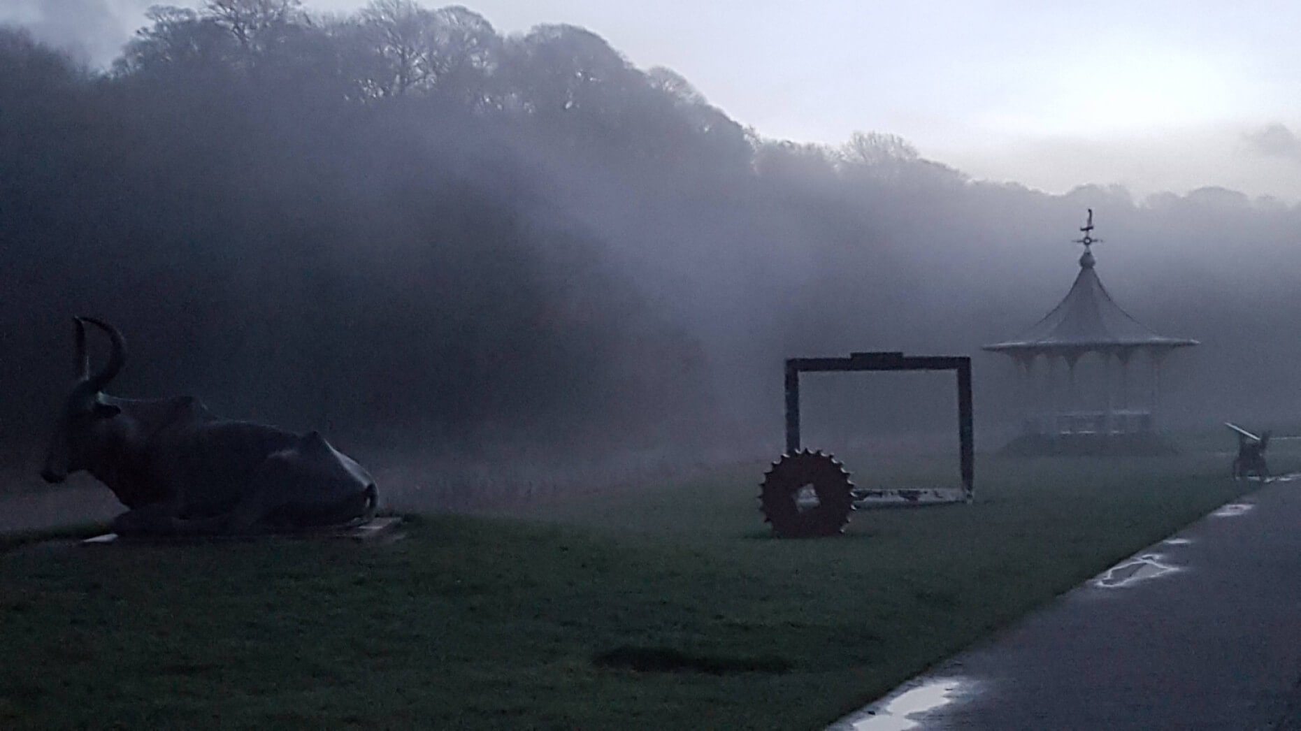 Misty path with bandstad and cow statue