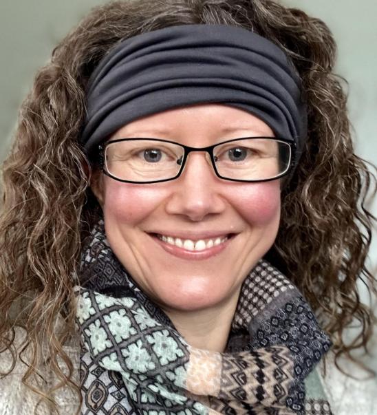 Melanie Counsellor head shot. Glasses, curly hair in a hairband